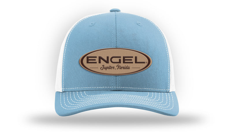 An Engel Columbia Blue & White 112 Trucker Cap by Richardson® with an Engel Leather Patch on it, featuring breathable mesh and snapback closure.