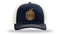 A navy Engel Columbia Navy & Khaki 112 Trucker Cap by Richardson® with a gold Engel Live Original Leather Patch logo on it.