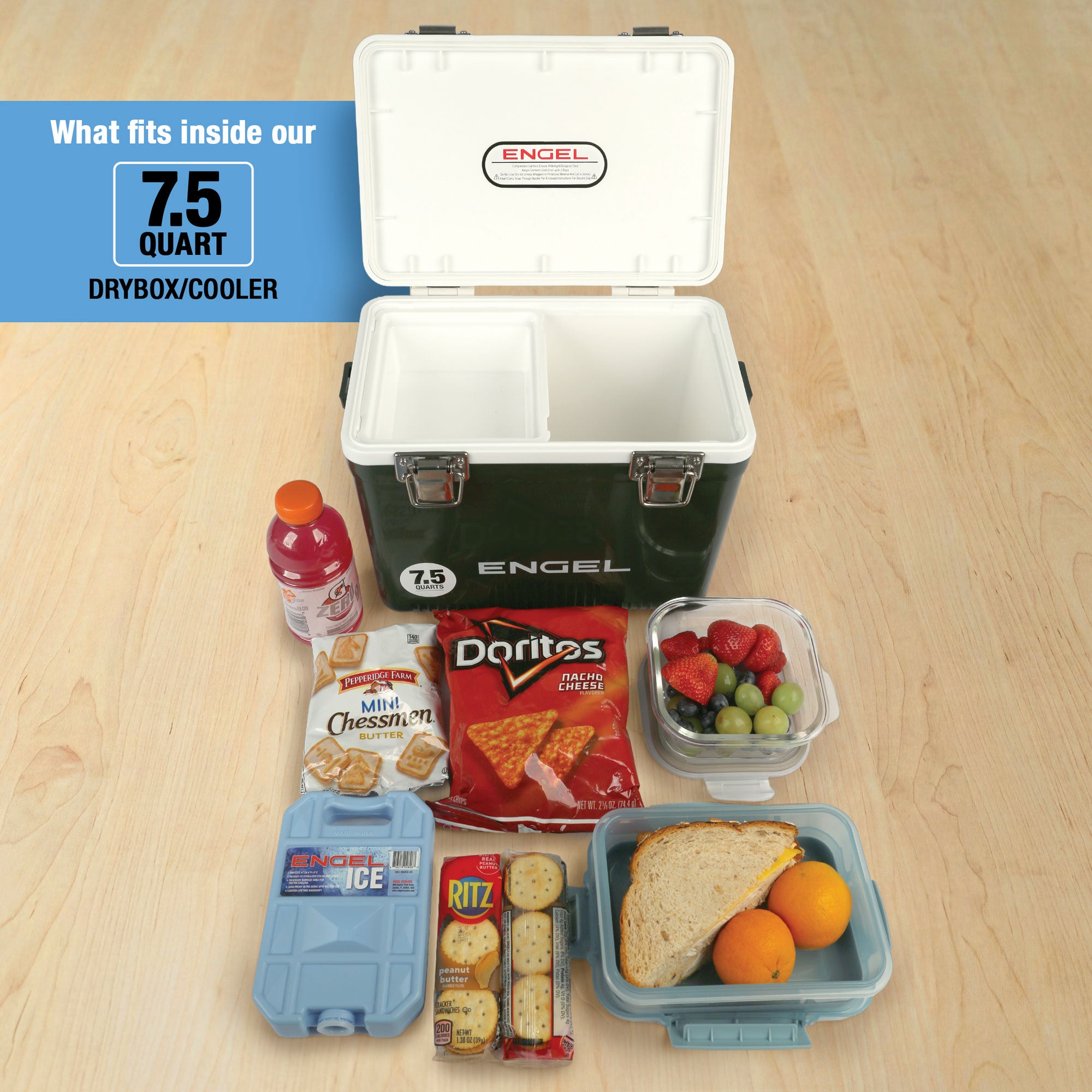 An open Engel Coolers 7.5 Quart Drybox/Cooler with compartments, displayed on a wooden floor and surrounded by sports drink, cookies, chips, crackers, fruit, and a sandwich—all as essential outdoor adventure gear.