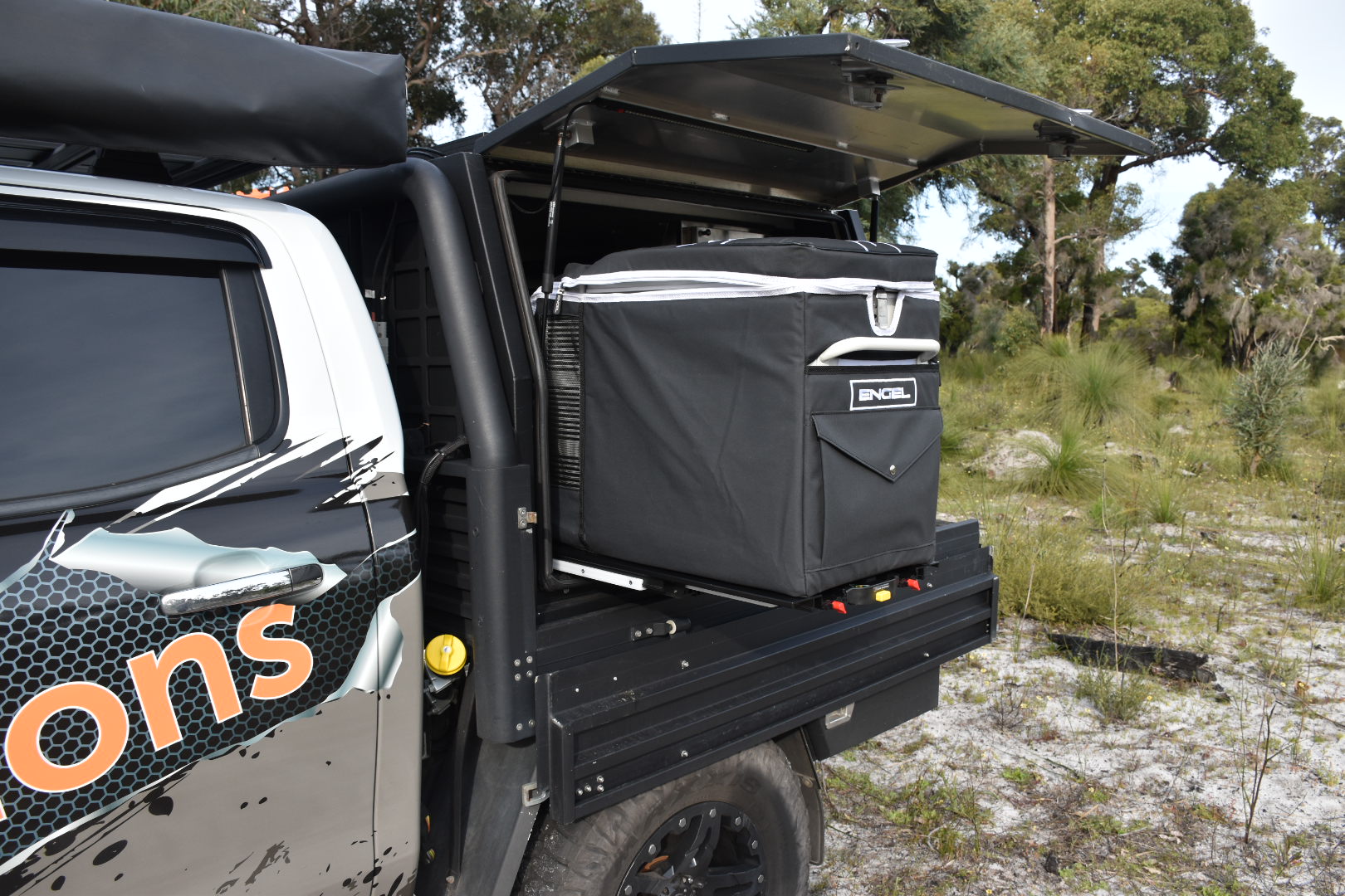 The back of a truck with an ENGEL Engel Standard Low-Profile Front Pull Fridge Slide cooler in it.