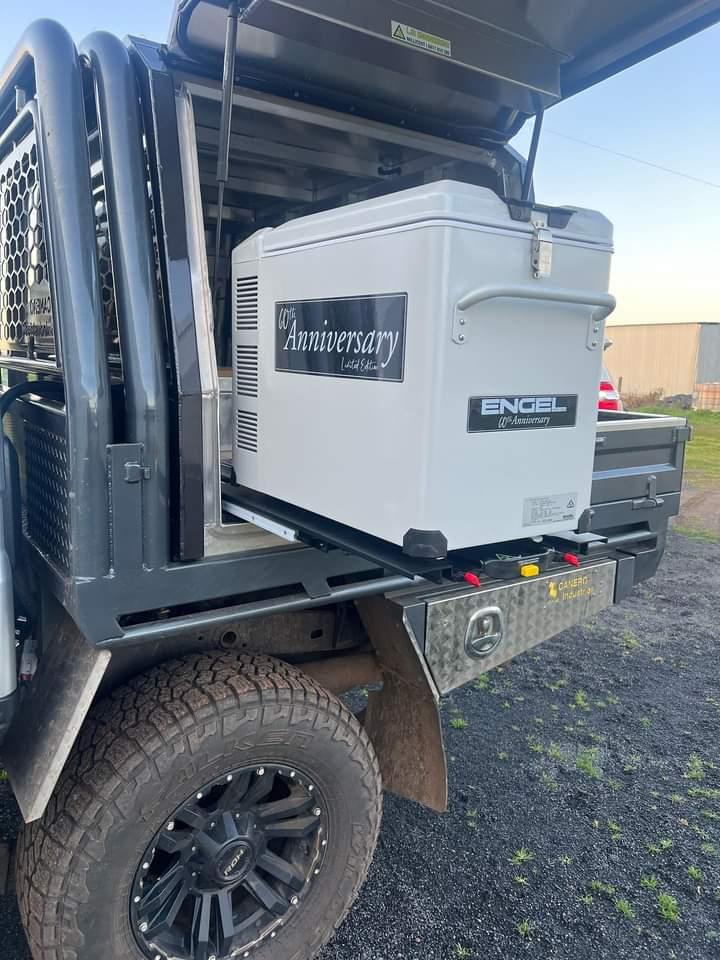 The back of a truck with an ENGEL Standard Low-Profile Front Pull Fridge Slide cooler attached to it.