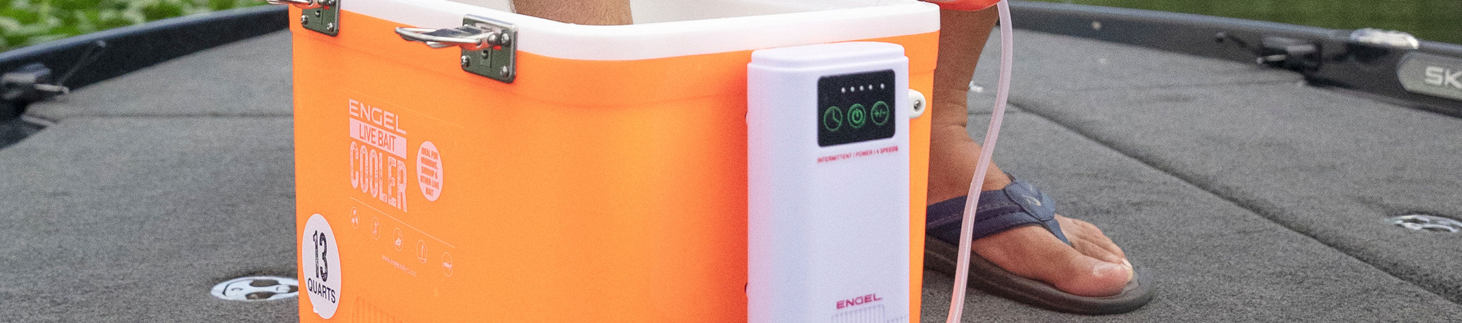 Person sitting near an orange cooler on a boat deck.