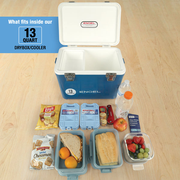 Top view of the Engel 13 Quart Drybox/Cooler by Engel Coolers on a wooden floor with sandwiches, fruits, snacks, water bottle, and ice packs—essential gear to keep your food fresh during outdoor adventures.