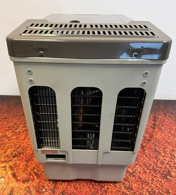 The Engel Coolers Engel MT27, a gray and black rectangular portable fridge freezer with ventilation grilles, screws, and a small opening at the bottom and equipped with a reliable Swing Motor compressor, is placed on a reddish-brown surface.