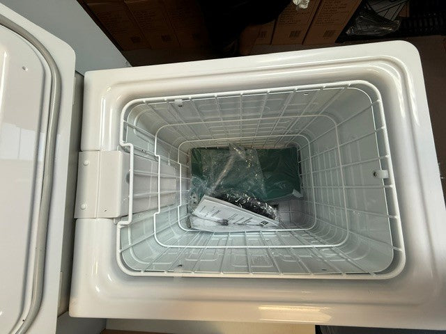 Top view of an empty white Engel Coolers MT45 Platinum Series (Refurbished) portable fridge-freezer, with a wire basket containing a plastic bag and papers, likely manuals or accessories, inside.