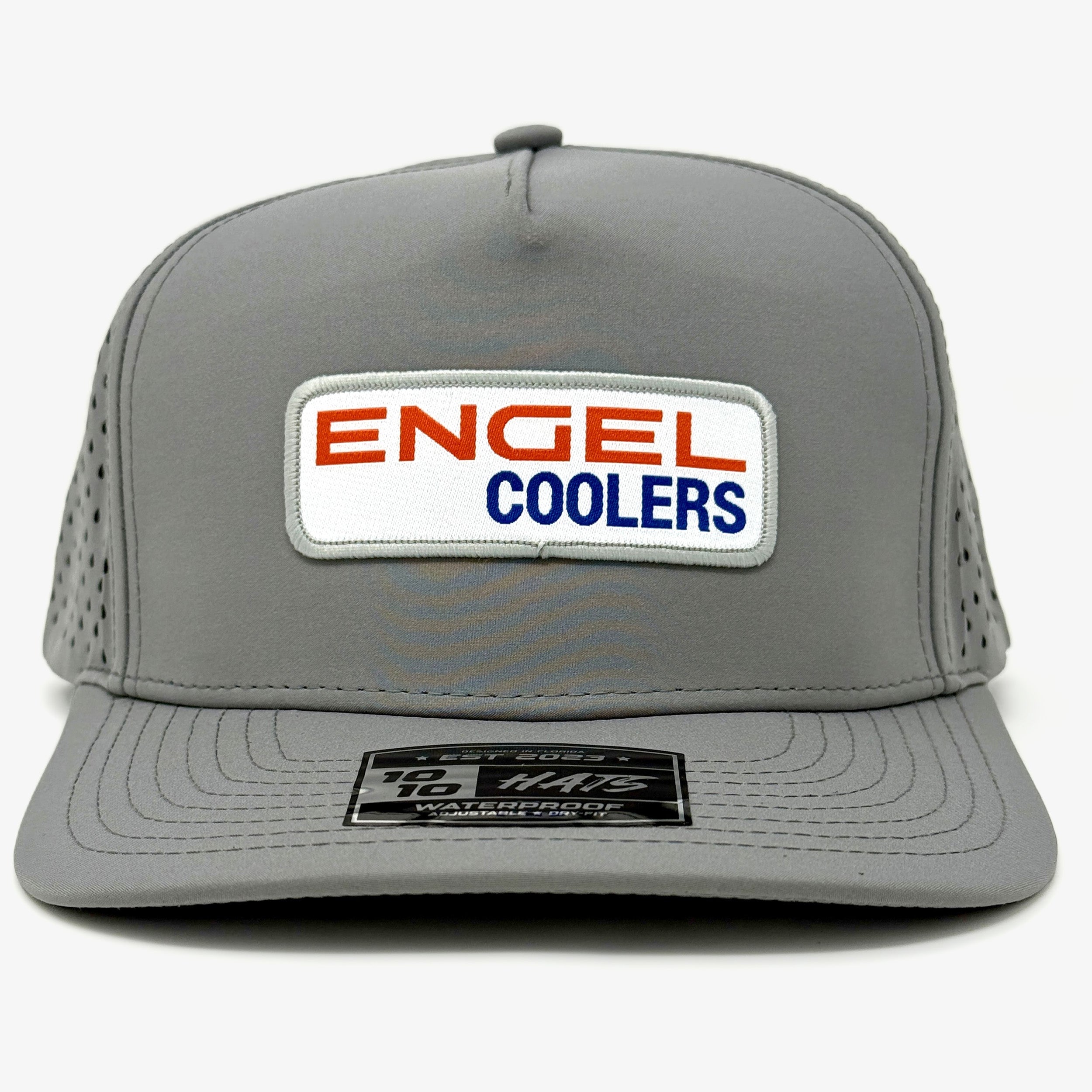 The Engel Coolers 1010 Performance Trucker Cap is a gray snapback with a perforated back for breathability, a front patch reading "ENGEL COOLERS" in red and blue, and a black sticker on the bill.