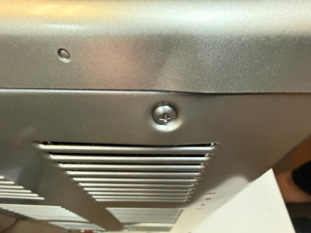 Close-up of a metallic surface with a screw and ventilation slits visible, characteristic of the durable exterior featured on the Engel MT45 Platinum Series (Refurbished) by Engel Coolers.