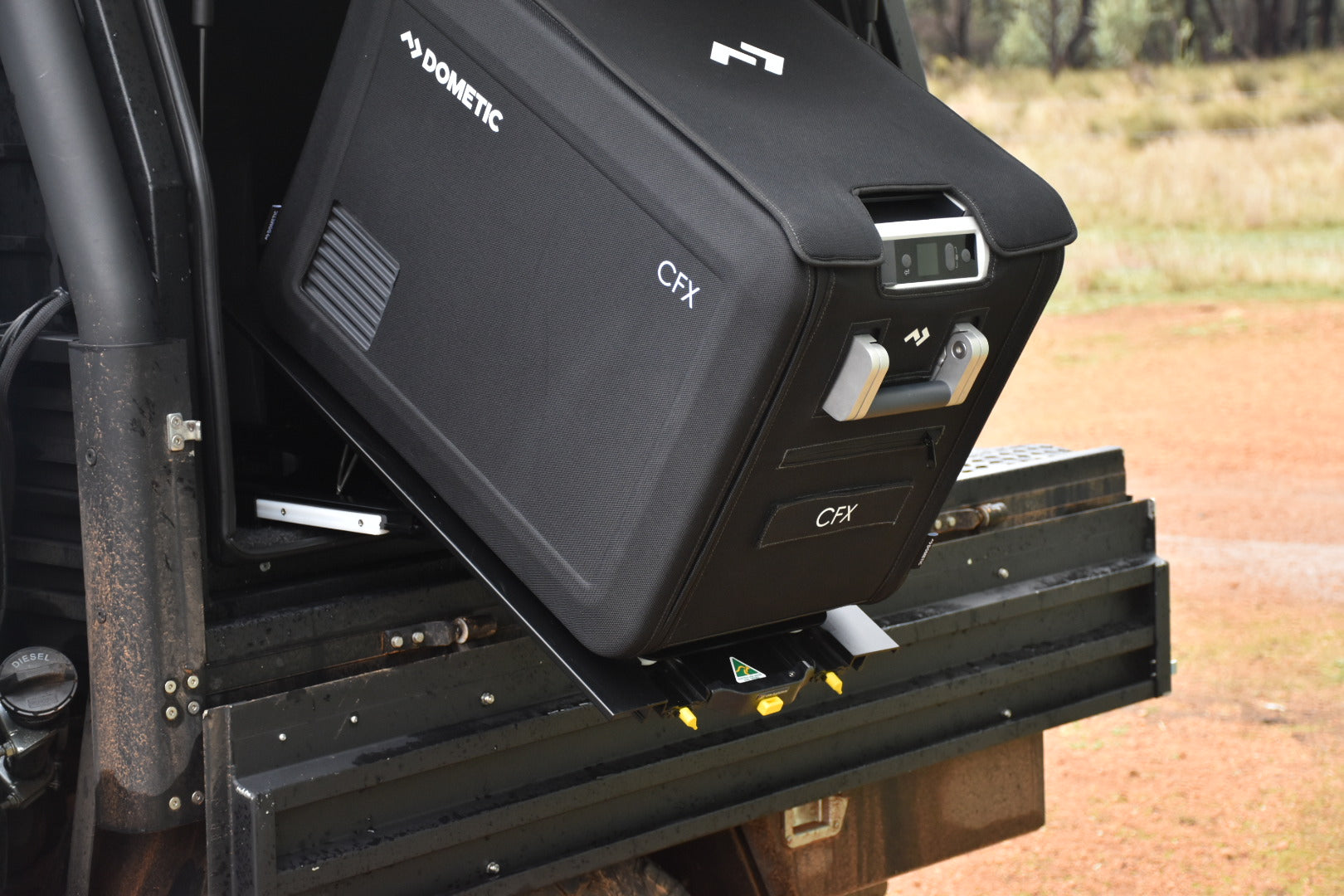 A black ENGEL cooler with an Engel Low-Profile Front-Pull Tilt Fridge Slide is attached to the back of a truck.