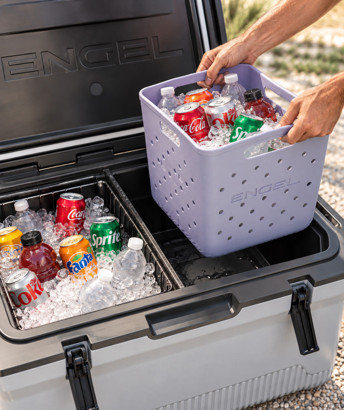 A person lifts a purple, perforated Engel Cooler Loader | Lightweight EVA Foam Cooler Caddy, 11″ x 11″ x 11″ filled with ice and drinks out of an open cooler.