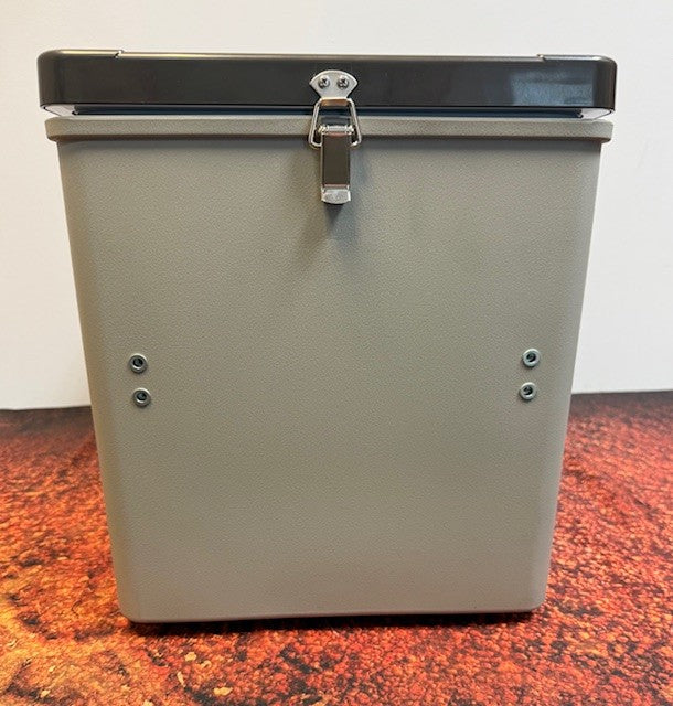 The Engel MT17F top-opening fridge-freezer by Engel Coolers features a rectangular gray metal body with a black latch-secured lid, shown on a red-speckled surface against a white background.