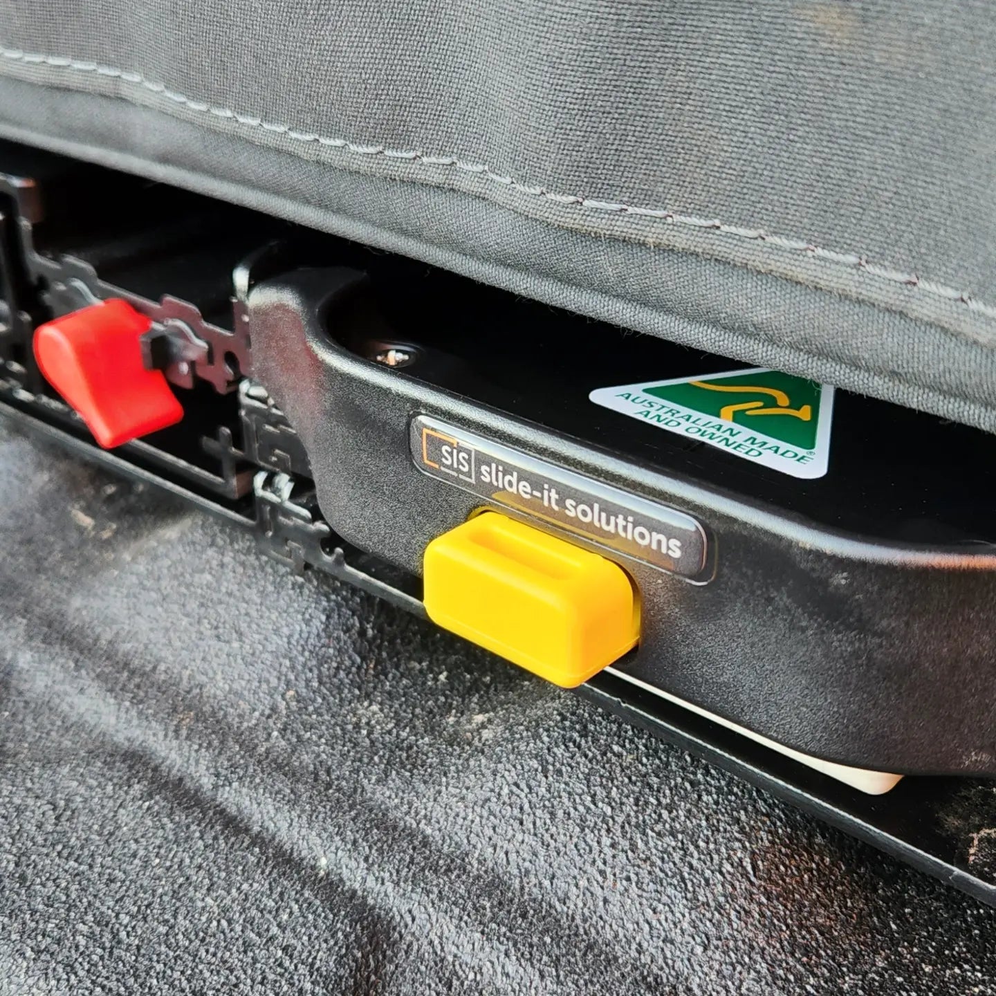 A black car with an ENGEL Low-Profile Front-Pull Tilt Fridge Slide on the seat featuring a tilt mechanism.