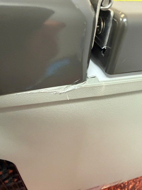 Close-up of a cracked and chipped area on the edge of a gray and white plastic surface, likely part of an Engel Coolers Engel MT27 fridge-freezer housing.
