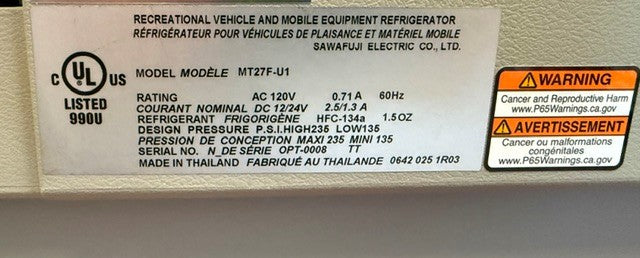 Close-up of a refrigerator information label showing model number, electrical specifications, refrigerant type, Swing Motor compressor details, warnings, and manufacturer information for the Engel MT27 fridge-freezer by Engel Coolers in English and French.