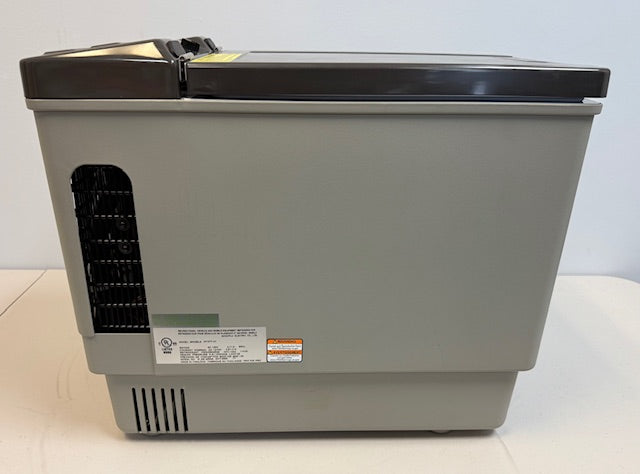 The Engel Coolers Engel MT27 fridge-freezer, in gray with a black vent and side labels, features variable temperature control. It sits on a light-colored surface against a plain wall.