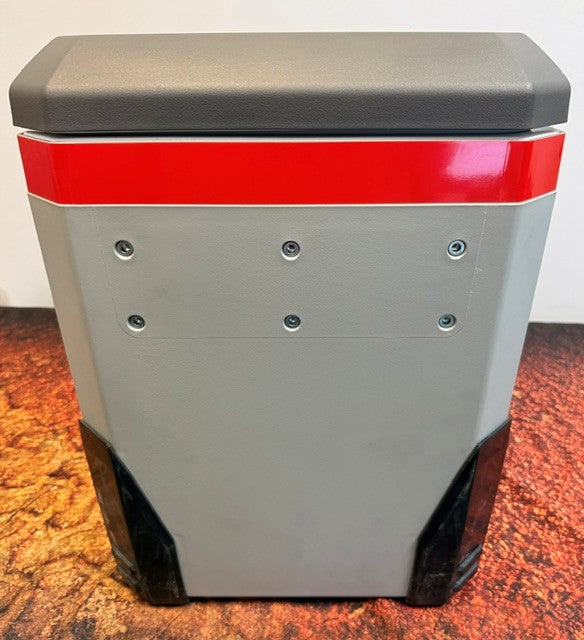 The Engel Coolers MR040 Top Opening Fridge-Freezer, featuring a grey and red plastic body with a dark grey lid, is equipped with a corrosion-resistant front panel secured by six silver screws and black corner protectors. It rests on a textured orange-brown surface, making it an ideal choice for use in marine environments.