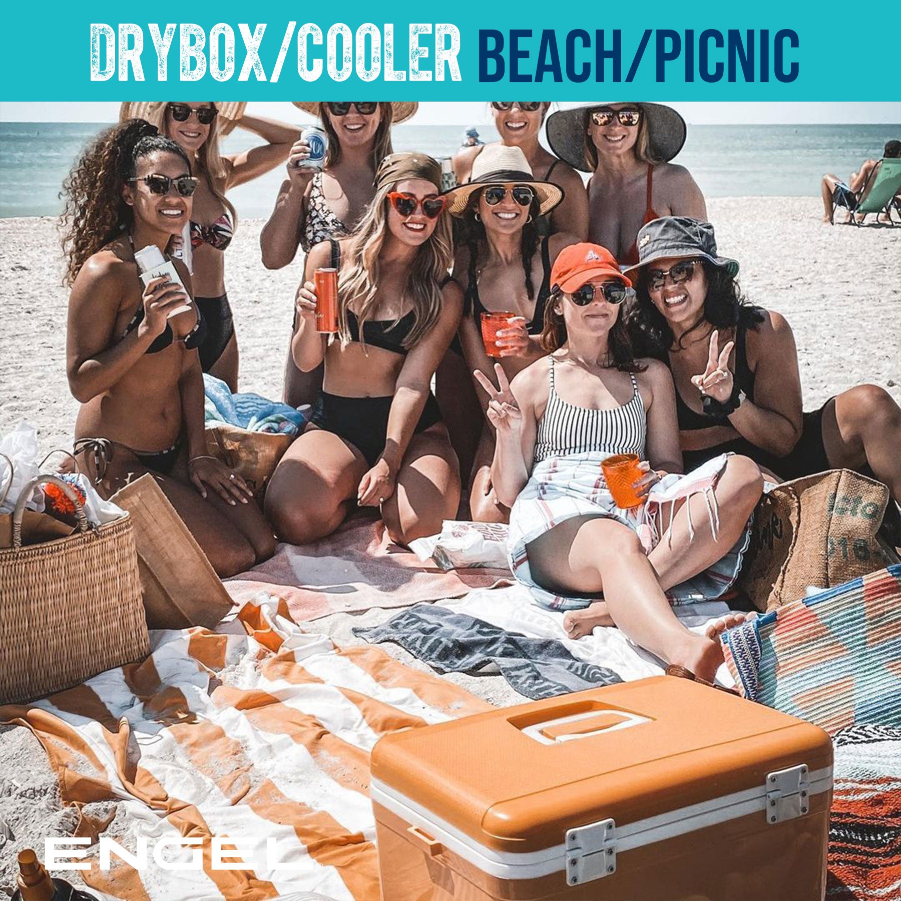 Group of women enjoying a picnic on the beach with an Engel 13 Quart Drybox/Cooler, snacks, and drinks, on a sunny day.