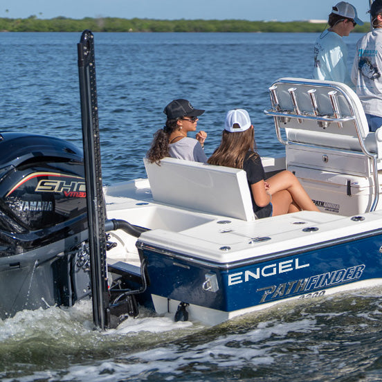 A small group of people sits in the back of a blue and white Pathfinder fishing boat named “Engel” on the water, heading away from the shore, with a 10" or 15" ENGEL White Vinyl Transfer from Engel Coolers catching the light on its stern.