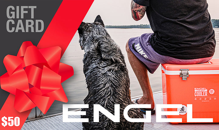 A person sitting on an Engel Cooler next to a dog, overlooking a serene body of water. A large red bow and an Engel Coolers Gift Card worth $50 add a splash of excitement, offering the perfect choice for those who cherish moments by the water.