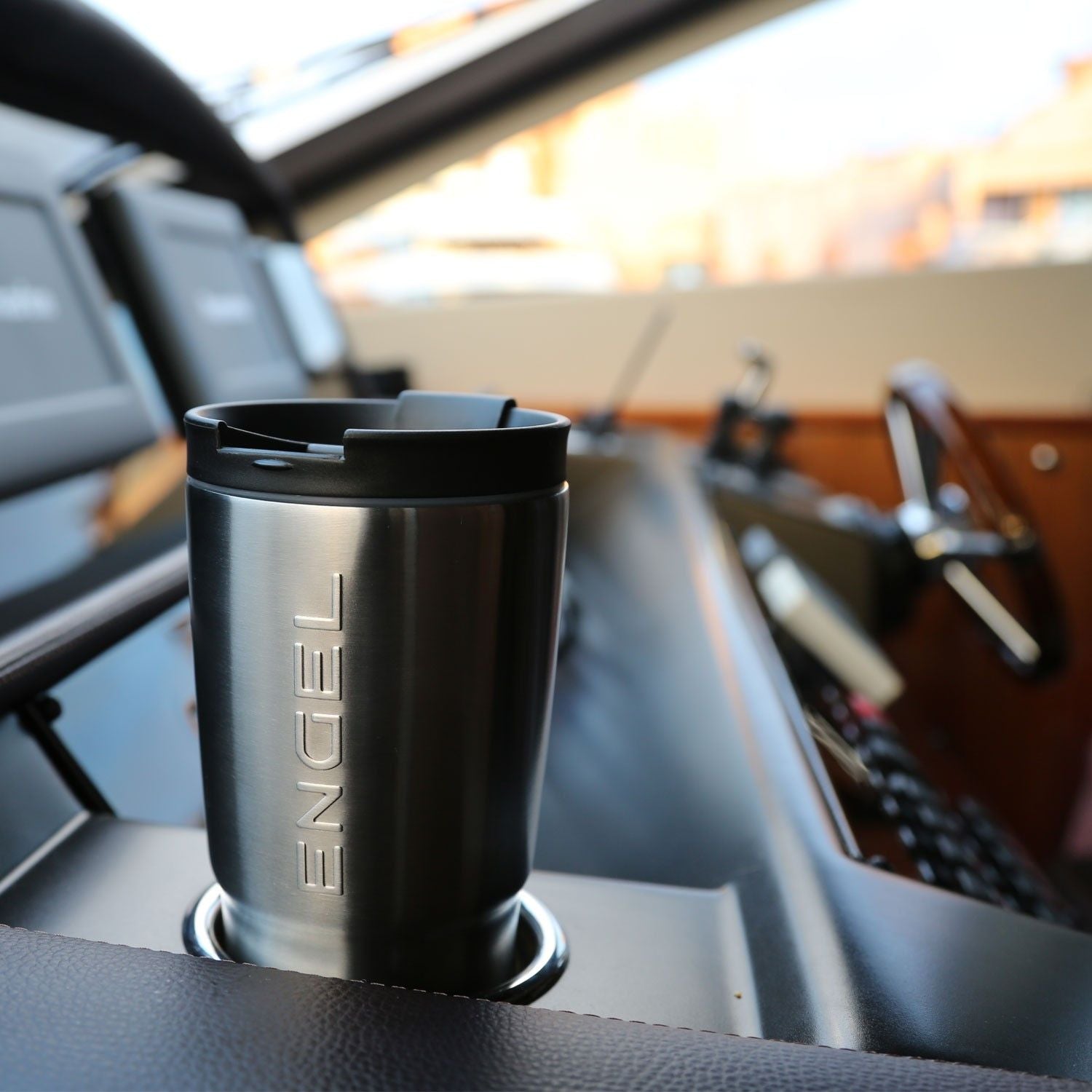 A Engel 30oz PRYM1 Camo Tumbler on the dashboard of a boat.