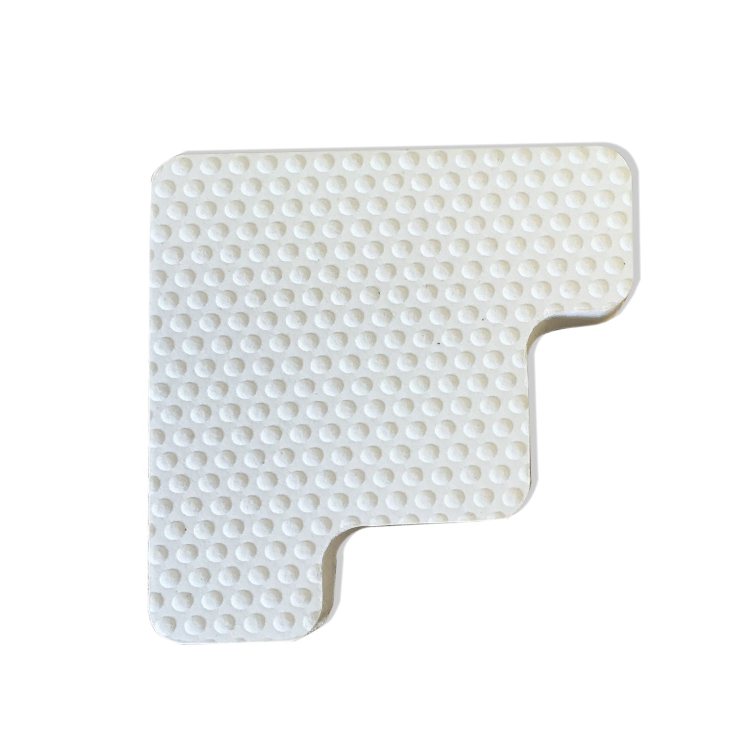 A white piece of plastic with dots on it, serving as an Engel Coolers Drybox Cooler Foam Feet.